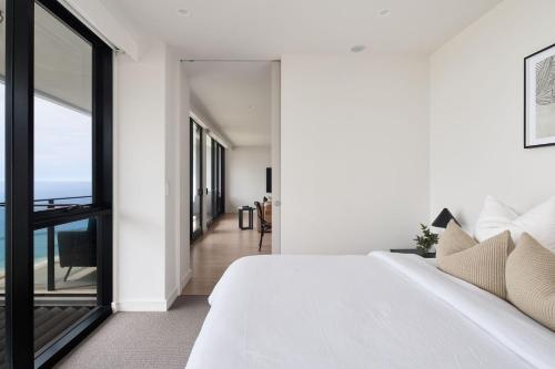 een slaapkamer met een wit bed en een groot raam bij The Outlook - 2 bed option in Newcastle