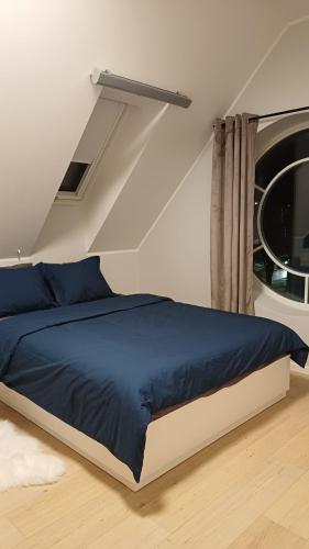 a bedroom with a blue bed and a window at Keila Round View Apartment in Keyla