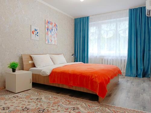 una camera da letto con un letto e una finestra con tende blu di 11 Microragion ad Aqtöbe