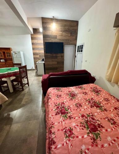 a bedroom with a red bed and a couch at Sueños de Mar in Mar del Tuyú