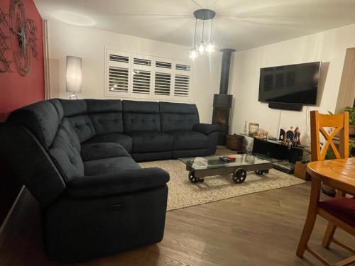 a living room with a black couch and a table at The Sails in East Wittering