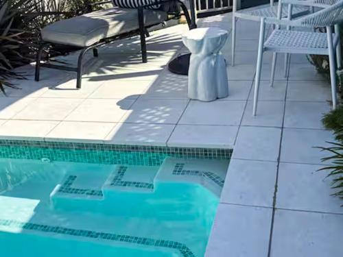 a swimming pool with a table and chairs next to it at Pool Heated Lake Views 1BR Apartment in Coal Point