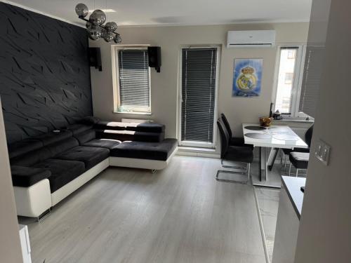 een woonkamer met een zwarte bank en een tafel bij PFB Premium Apartment in Słubice