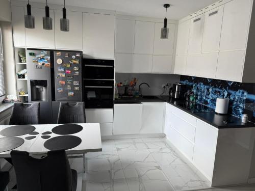 een keuken met witte kasten en een tafel met stoelen bij PFB Premium Apartment in Słubice