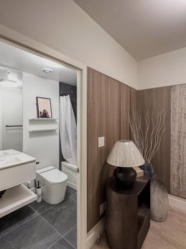 a bathroom with a toilet and a lamp on a table at Luxury 40th-Floor Lakeview 2BR with PATH & Union Access in Toronto