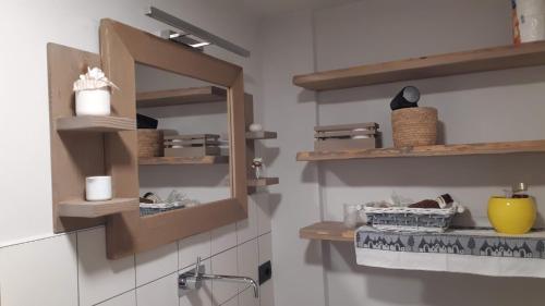 a kitchen with wooden shelves on the wall at Da Milena in Frabosa Sottana