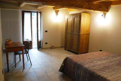 une chambre avec un lit, une table et un bureau dans l'établissement Da Milena, à Frabosa Sottana