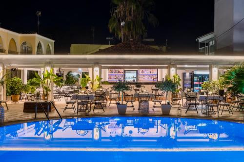a pool in front of a restaurant at night at Konstantina Apartments in Kavos
