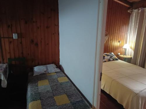 a small bedroom with a bed and a table with a lamp at Hostería Don Atilio in Posadas