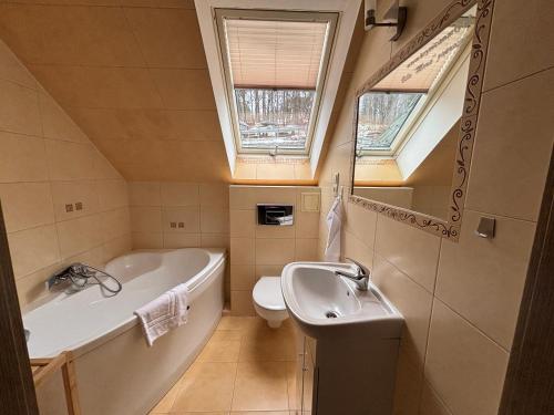 a bathroom with a bath tub and a sink at Willa Marie in Krynica Zdrój