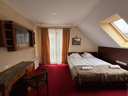 a hotel room with a bed and a window at Willa Marie in Krynica Zdrój