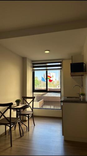 a room with a table and chairs and a window at Suite Prado-PC0n Garant1a in Cochabamba