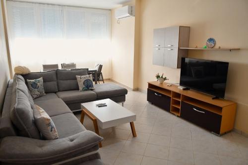 a living room with a couch and a flat screen tv at Coastal Calm in Golem