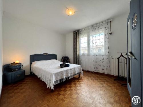 een slaapkamer met een bed en een groot raam bij La sapinette in Quillan