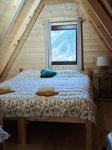 a bed in a room with a window at Vikendica Neven 3 in Popovići