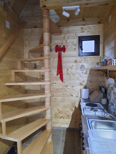 een blokhutkeuken met houten trap en een kachel bij Vikendica Neven 3 in Popovići