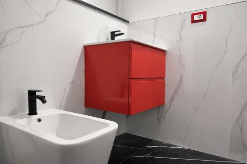 ein Badezimmer mit einem roten Schrank und einem Waschbecken in der Unterkunft Maison Valentino in Mailand