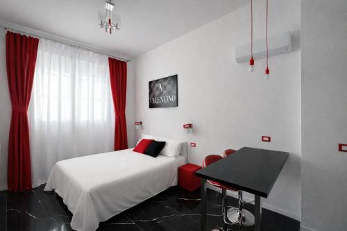 ein Schlafzimmer mit einem Bett, einem Tisch und einem Schreibtisch in der Unterkunft Maison Valentino in Mailand