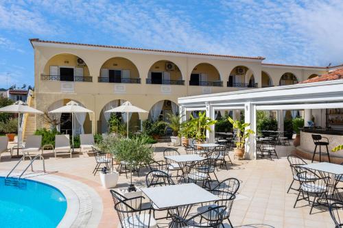a patio with tables and chairs next to a pool at Konstantina Apartments in Kavos