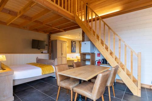 een slaapkamer met een bed, een tafel en stoelen bij B&B De Leestjespolder in Moerkerke