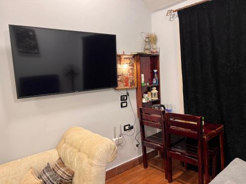a living room with a couch and a television on a wall at iBiZa Hostel in Beni Suef