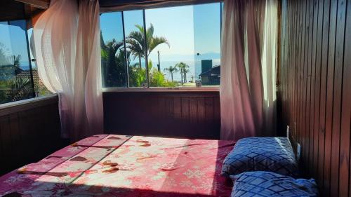 una camera da letto con un letto e una finestra con vista di Cabana Raio de Sol RS a Osório