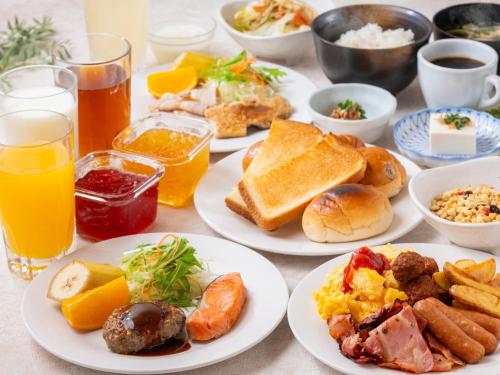 a table with plates of breakfast foods and drinks at APA Hotel Higashi Shinjuku Kabukicho in Tokyo