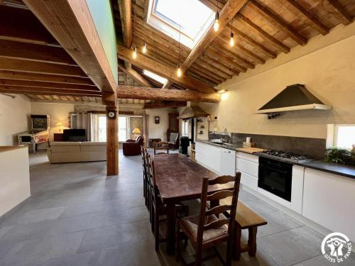 une cuisine avec une table et des chaises dans une pièce dans l'établissement La ruche, à Durban-Corbières