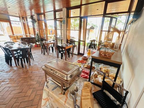 een eetkamer met tafels en stoelen en een tafel met eten bij Pousada Ponta dos Corais in Guarujá