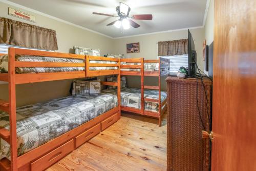 a bedroom with two bunk beds and a ceiling fan at Hot Tub, Fire Pit and Lake Access! Almond Cabin in Almond