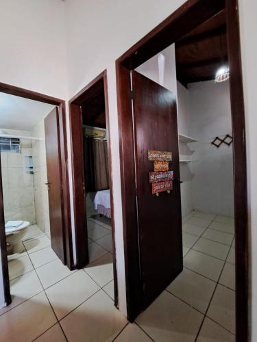 a bathroom with a door with a sign on it at Pousada Pipa Bela in Pipa