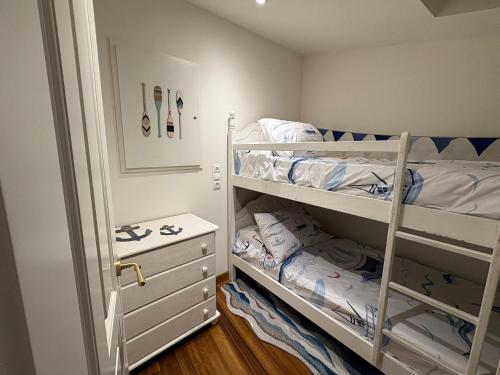 a small bedroom with two bunk beds and a dresser at CASINA La RIBERA in Cudillero