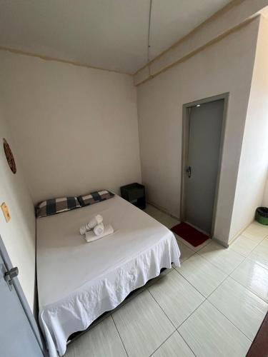 a bedroom with a white bed with a towel on it at Pousada e Hostel Santos in Barreirinhas