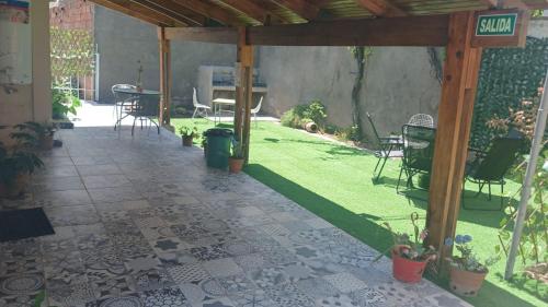 een terras met een tafel en stoelen in een tuin bij Artin House Mendoza in Ciudad Lujan de Cuyo