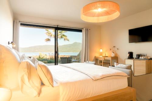 a bedroom with a bed with a view of the ocean at Boutique hôtel Château Rouher in Propriano