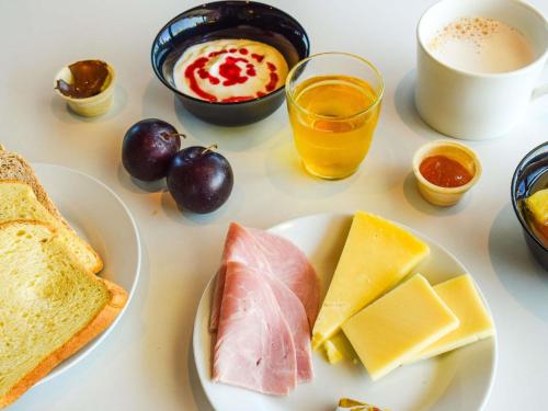 a table with a plate of cheese and bread and a cup of coffee at ibis budget Rodez in Rodez