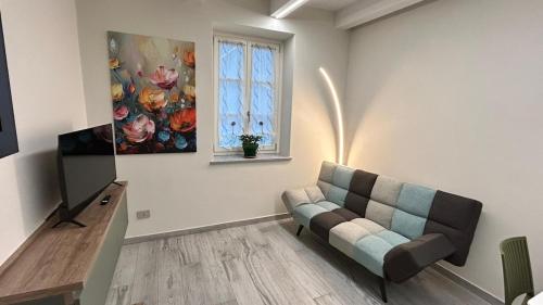 a living room with a couch and a television at Baratà Apartments 2 in Savigliano