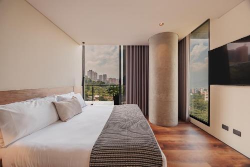 a bedroom with a large bed and a large window at Kiin Living- "Child-free coliving" in Medellín