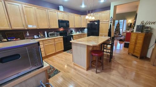 a large kitchen with wooden cabinets and a counter top at Mt Rainier Way Bedroom with Private Full Bath in Eatonville