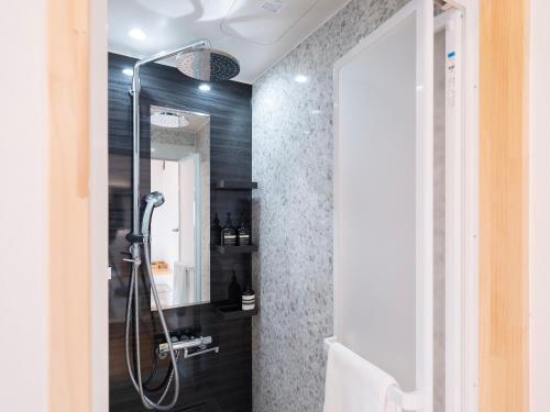 a bathroom with a shower and a mirror at On The Cliff in Karatsu