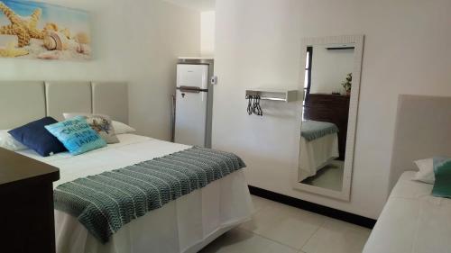een kleine kamer met een bed en een spiegel bij Suíte Praia do Peró in Cabo Frio