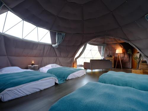 a bedroom with two beds in a tent at On The Cliff in Karatsu