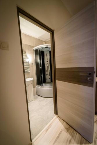 a door leading to a bathroom with a mirror at Apartamenty Wałowa 4 in Tarnów