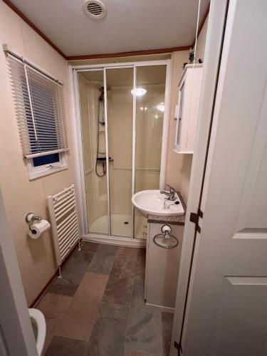 a bathroom with a shower and a sink at A & C Coastal Hideaway with outside Decking in East Mersea