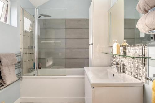 ein weißes Badezimmer mit Waschbecken und Dusche in der Unterkunft 1 Bed in Dickleburgh oc-m33974 in Dickleburgh