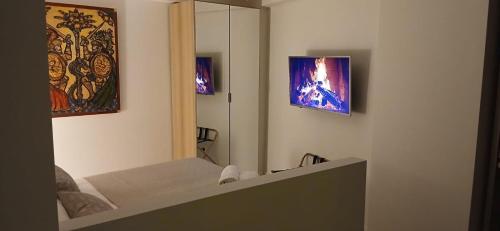 een kamer met een bed, een spiegel en schilderijen bij Tao chambre in Taormina