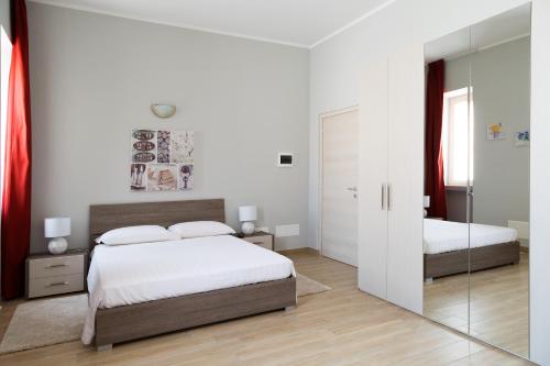 a bedroom with two beds and a mirror at La Viscontina in Somma Lombardo