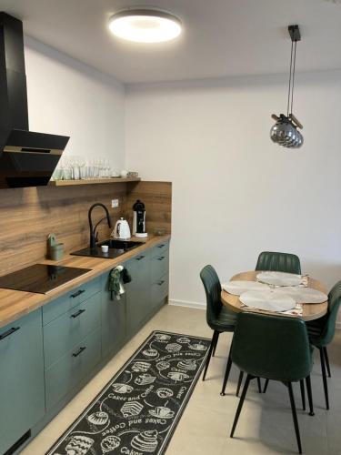 une cuisine avec une table, des chaises et un évier dans l'établissement Apartman SKY Tatry, à Veľký Slavkov