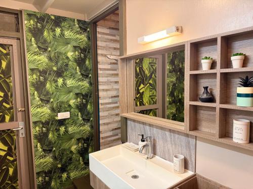 a bathroom with a sink and a green wall at Faaora Lodge, little paradise Moorea in Haapiti