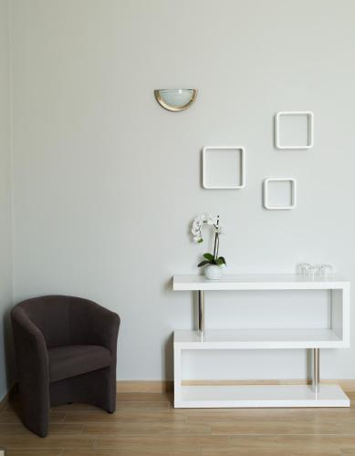 a living room with a chair and a white table at La Viscontina in Somma Lombardo
